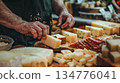 Cheese seller cutting cheese on wooden board in shop 134776041