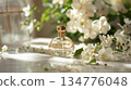 Elegant perfume bottle resting on marble surface with white flowers 134776048