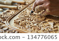 Carpenter carving wood in workshop using chisel 134776065