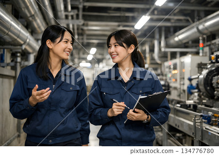 Female engineers patrolling the factory to check the work Female engineers patrolling the factory to check the work 134776780