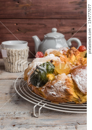 King Cake with nuts - Bolo Rei is a traditional Xmas cake with fruits raisins nut and icing on wooden table 134777077