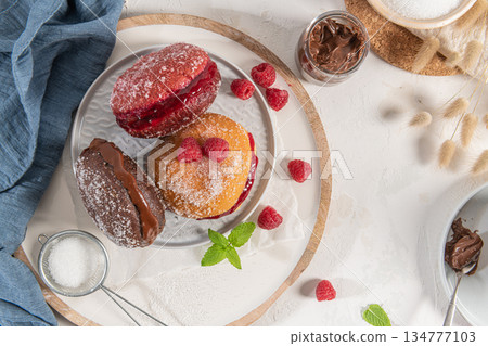 Bolas de Berlim, or "Berlin Balls". Portuguese fried dough with sugar, Filled with chocolate or raspberry jam. Portuguese fried dough with sugar. Chocolate and beetroot berliner Pancakes Doughnuts Bolas de Berlim, or "Berlin Balls". Portuguese fried dough with sugar, Filled with chocolate or raspberry jam. Portuguese fried dough with sugar. Chocolate and beetroot berliner Pancakes Doughnuts 134777103