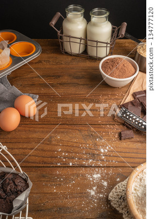 Products and objects for baking chocolate cake on dark wooden table. Concept of home baking. Products and objects for baking chocolate cake on dark wooden table. Concept of home baking. 134777120