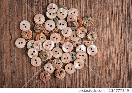 Set of different colored buttons over rustic wooden texture.Top view with copy space. Set of different colored buttons over rustic wooden texture.Top view with copy space. 134777249