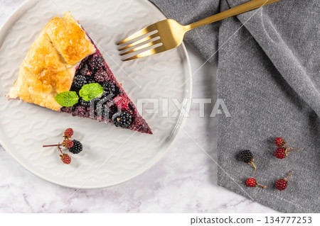 Slice of blackberries pie. Pie in summer with fresh picked wild blackberries. Top view. 134777253