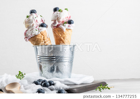 Homemade blueberries ice cream in waffle cones and fresh blueberries. Homemade blueberries ice cream in waffle cones and fresh blueberries. 134777255