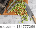 Heap of green beans on a rustic wooden table top view. Cutting board with green beans. 134777269