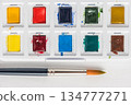 Box of watercolor paints and brushes 134777271