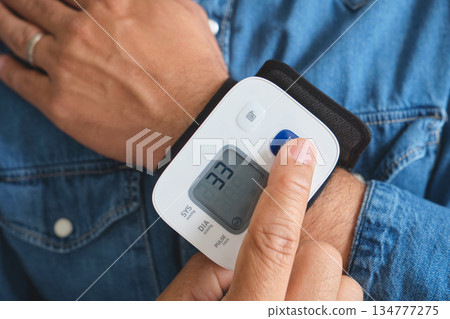Person measuring wrist blood pressure at home Person measuring wrist blood pressure at home 134777275