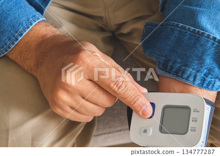 Person measuring own blood pressure for health monitoring Person measuring own blood pressure for health monitoring 134777287