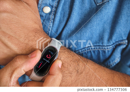 Man monitoring heart rate with fitness tracker on wrist 134777306