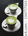 Two cups of matcha latte on black table 134777503