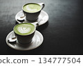 Two cups of matcha latte on black table 134777504
