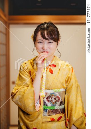 一位身著傳統日式服裝的年輕女子正在玩老式玩具 134777574