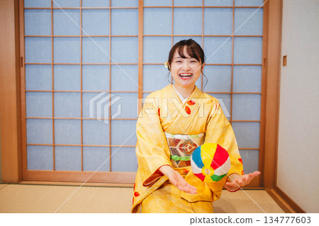 一位身穿和服的美麗年輕女子在玩紙氣球 134777603