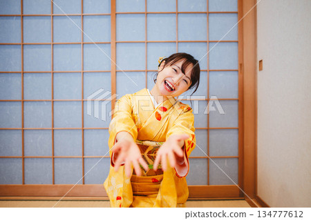 一位身穿和服的美麗年輕女子在玩紙氣球 一位身穿和服的美麗年輕女子在玩紙氣球 134777612