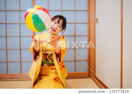 一位身穿和服的美麗年輕女子在玩紙氣球 134777614