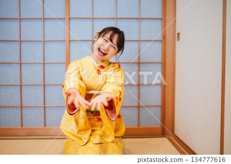 一位身穿和服的美麗年輕女子在玩紙氣球 一位身穿和服的美麗年輕女子在玩紙氣球 134777616