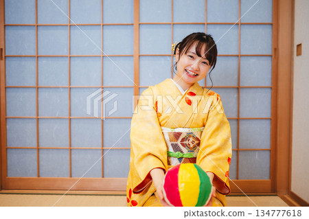 A beautiful young woman in a kimono playing with paper balloons A beautiful young woman in a kimono playing with paper balloons 134777618