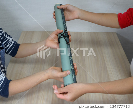 孩子們傳遞捲軸的特寫鏡頭 孩子們傳遞捲軸的特寫鏡頭 134777713