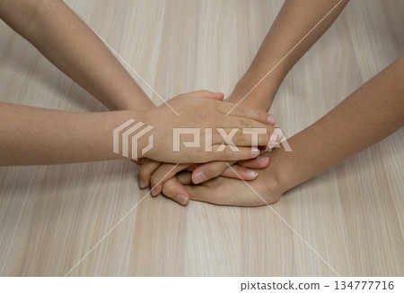 孩子們疊在一起的手的特寫鏡頭 孩子們疊在一起的手的特寫鏡頭 134777716