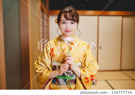 身著日式服裝、手捧鮮花的年輕女子 身著日式服裝、手捧鮮花的年輕女子 134777734