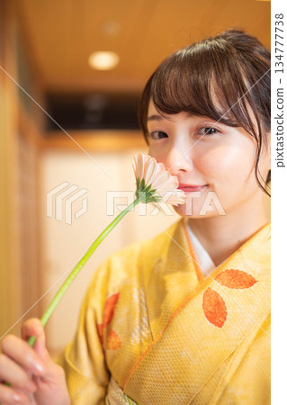 身著日式服裝、手捧鮮花的年輕女子 134777738