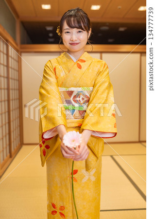 Young woman in Japanese clothing with flowers 134777739