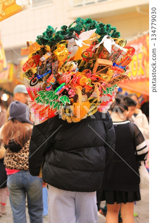 埼玉縣河口市鳩穀神社岡龜市場：一名男子手持耙子 134779030