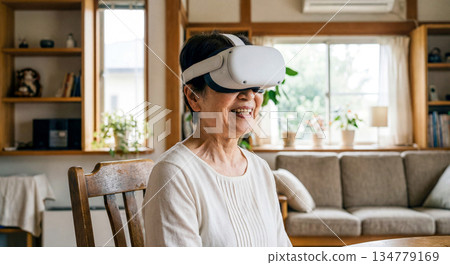 一位微笑的老婦人戴著VR眼鏡，正在享受虛擬實境。 134779169