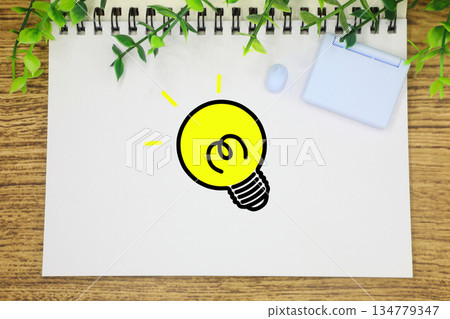 Miniature light bulb on sketchbook Miniature light bulb on sketchbook 134779347
