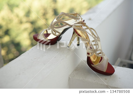 Stylish and highly fashionable woman high heeled shoes with trendy accessories, captured on a colorful background, exuding luxury and elegance perfect for wedding or formal outfit inspiration Stylish and highly fashionable woman high heeled shoes with trendy accessories, captured on a colorful background, exuding luxury and elegance perfect for wedding or formal outfit inspiration 134780508