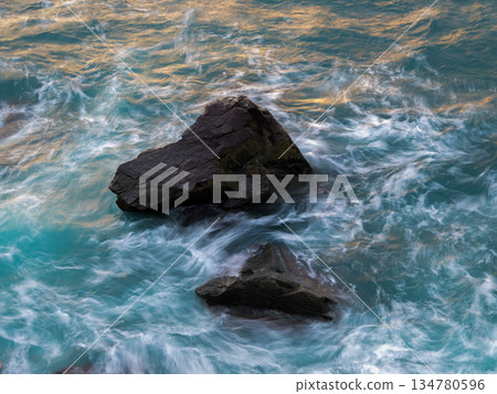 日落時分的礁石和洶湧的海面 日落時分的礁石和洶湧的海面 134780596