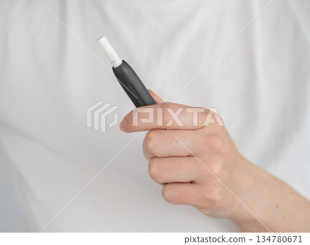 Faceless woman holding tobacco heating system. Faceless woman holding tobacco heating system. 134780671