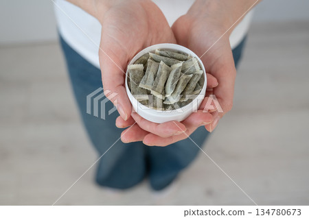 A woman holds a jar of chewing tobacco.  134780673