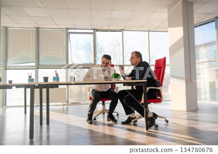Two Caucasian men solve problems at work. Two Caucasian men solve problems at work. 134780676