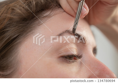 Caucasian woman getting eyebrow tinting procedure.  134780694