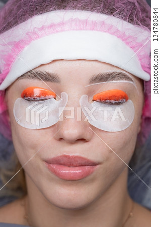 Caucasian woman undergoing eyelash lamination procedure. top view.  134780844