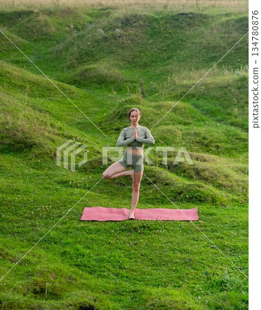 Caucasian woman doing yoga outdoors. Tree pose. Caucasian woman doing yoga outdoors. Tree pose. 134780876