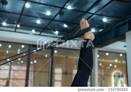 Caucasian woman doing exercises on reformer machine. Caucasian woman doing exercises on reformer machine. 134780885