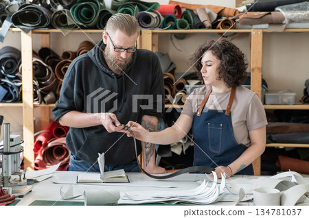 A man and a woman work as tanners in a workshop. A man and a woman work as tanners in a workshop. 134781037