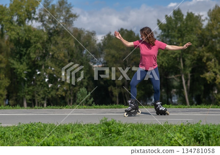 Caucasian woman roller skating in park.  134781058