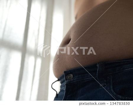 A fat belly spilling out of pants 134783830