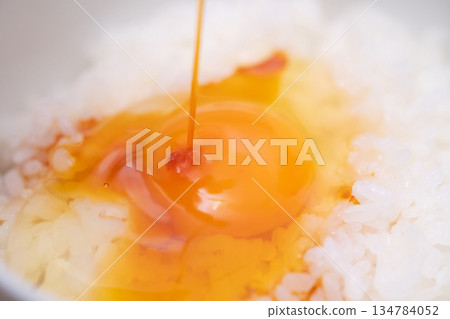 一張鮮蛋蓋在飯上，淋上醬油的圖片 134784052