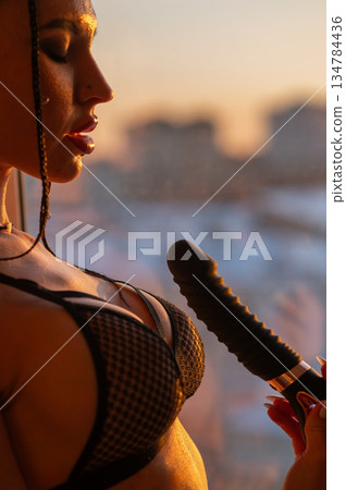 Caucasian woman holding a black dildo. Caucasian woman holding a black dildo. 134784436