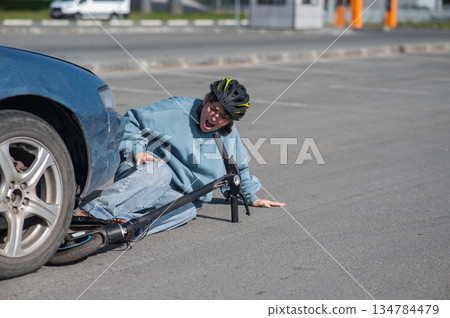 A Caucasian woman on a scooter after being hit by a car. 134784479