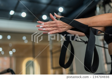 Caucasian woman doing exercises on reformer machine. Caucasian woman doing exercises on reformer machine. 134784698