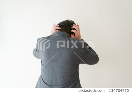 Rear view of a businessman holding his head Rear view of a businessman holding his head 134784770