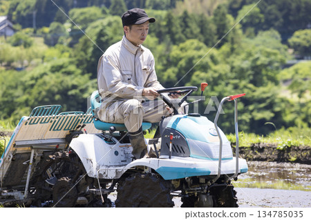 A young male rice farmer planting rice with a rice planting machine 134785035