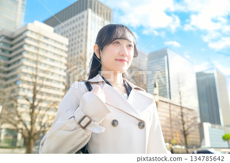A woman looking up at the sky in an office district A woman looking up at the sky in an office district 134785642